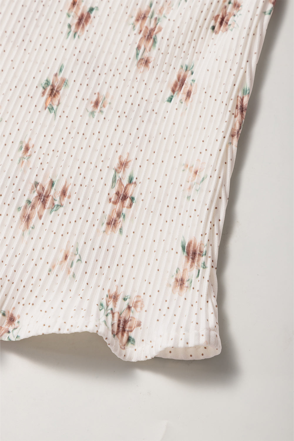Pleated floral tank top with polka dots and a bow back detail.