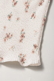 Pleated floral tank top with polka dots and a bow back detail.