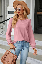 Pink textured puff sleeve blouse with ruffle cuffs and crew neck.