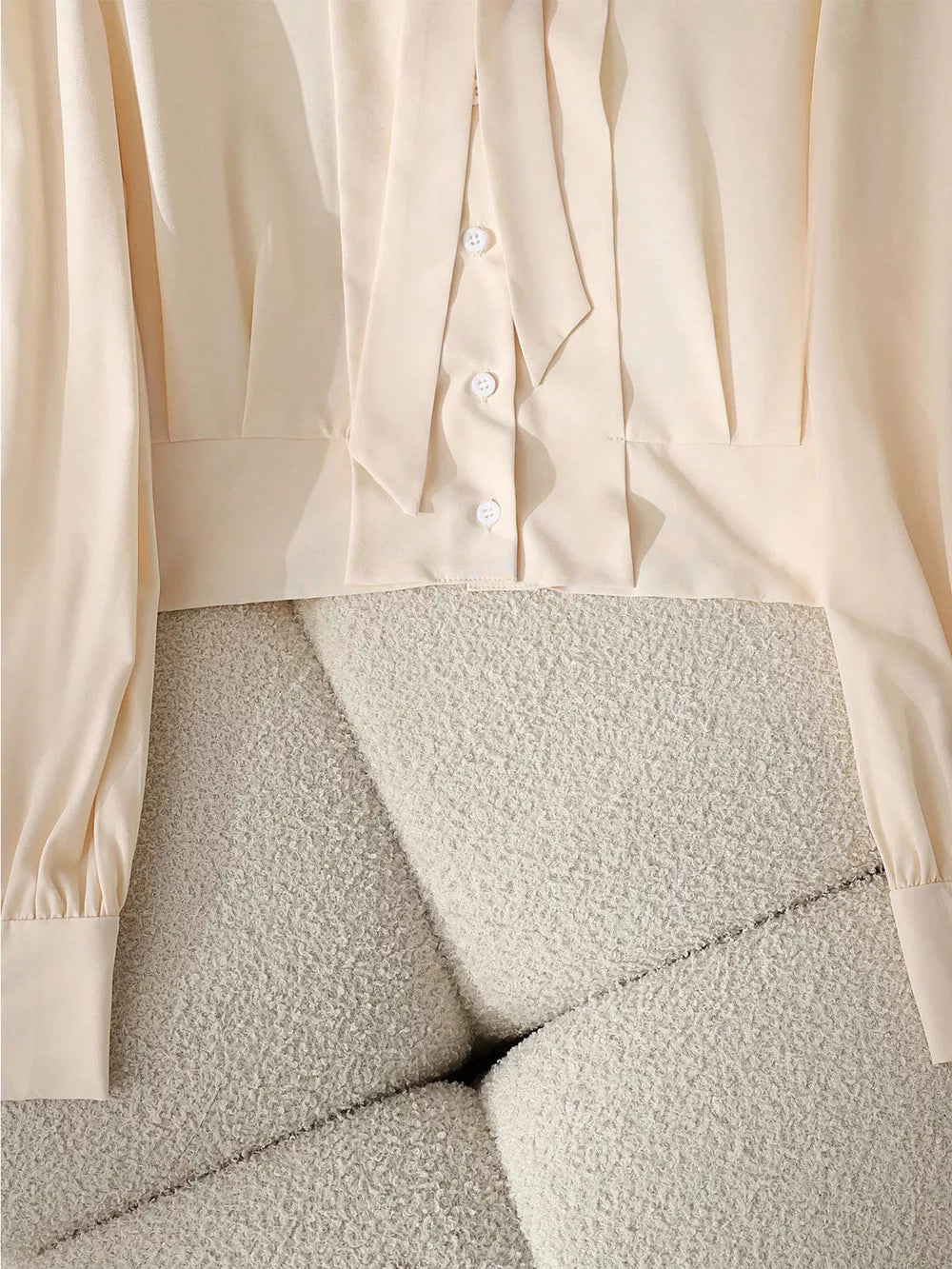 Apricot bow tie blouse with button front and long sleeves.