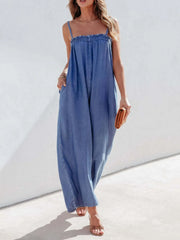 Medium denim jumpsuit with gathered bodice, spaghetti straps, and wide legs.