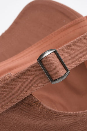 Coral baseball cap detail showing adjustable strap and metal buckle
