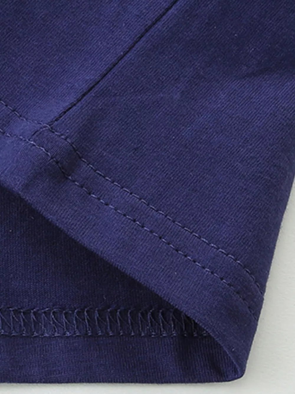 Toddler navy blue cotton crew neck t-shirt detail showing stitching.
