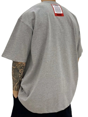 Gray oversized t-shirt with red VETEMENTS label on back.