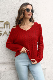 Red V-neck cable knit sweater with cold shoulder detail and long sleeves.