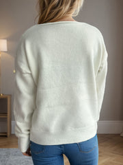 Relaxed-fit white acrylic V-neck sweater with ribbed hem and cuffs.