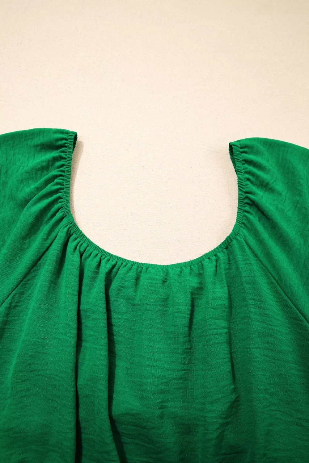 Green ruched maternity peplum shirt with a gathered neckline and textured polyester fabric.