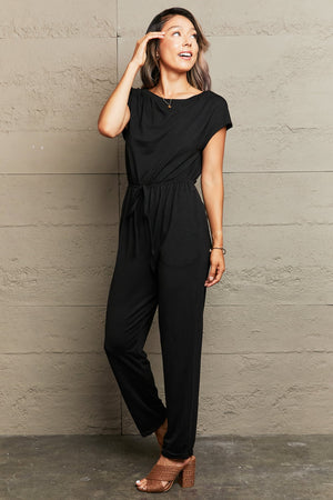Black cap sleeve jumpsuit with drawstring waist and boat neck.