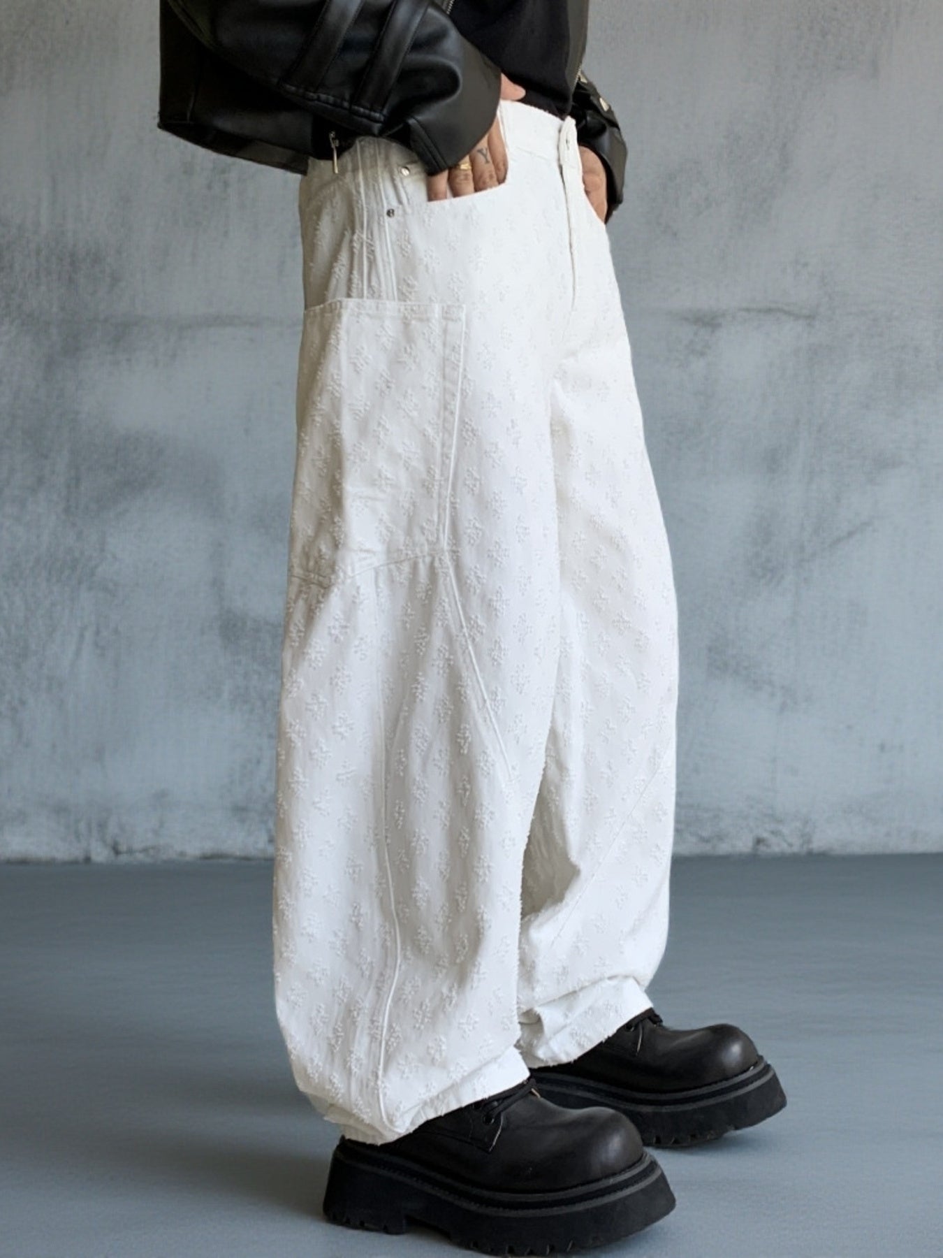 White textured cotton wide-leg jeans for men with curved seams and large front pockets.