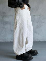 White textured cotton wide-leg jeans for men with curved seams and large front pockets.