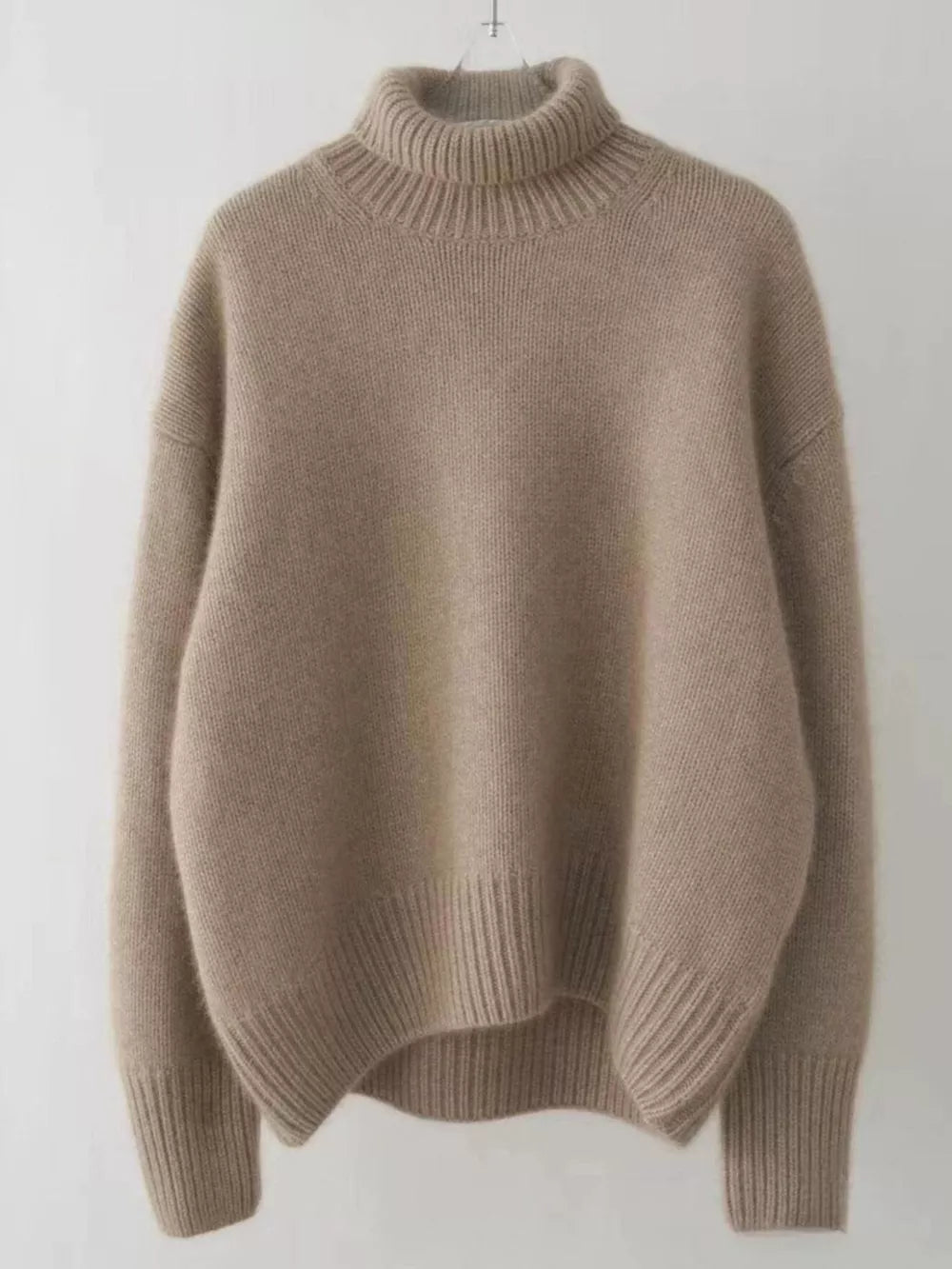 Beige acrylic knit turtleneck sweater with dropped shoulders and ribbed cuffs and hem.