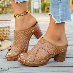 Tan peep-toe block heel mules with cut-out diamond pattern and white stitching.