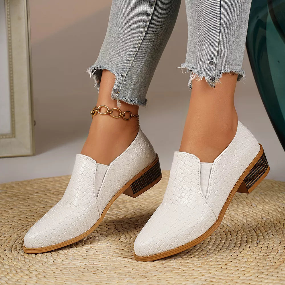 White woven texture pointed loafers with block heels and gold ankle chain.
