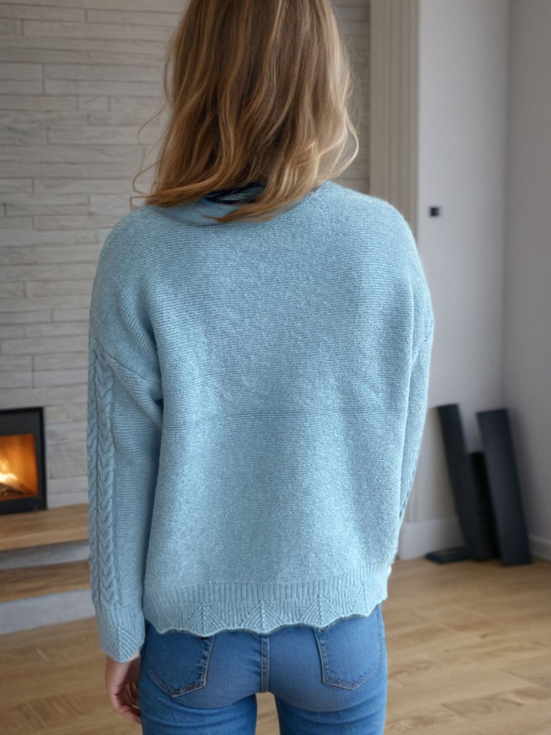 Light blue acrylic cable knit mock neck sweater with textured sleeves and scalloped hem.