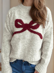 Beige knit sweater with a crimson bow intarsia design and crew neck.