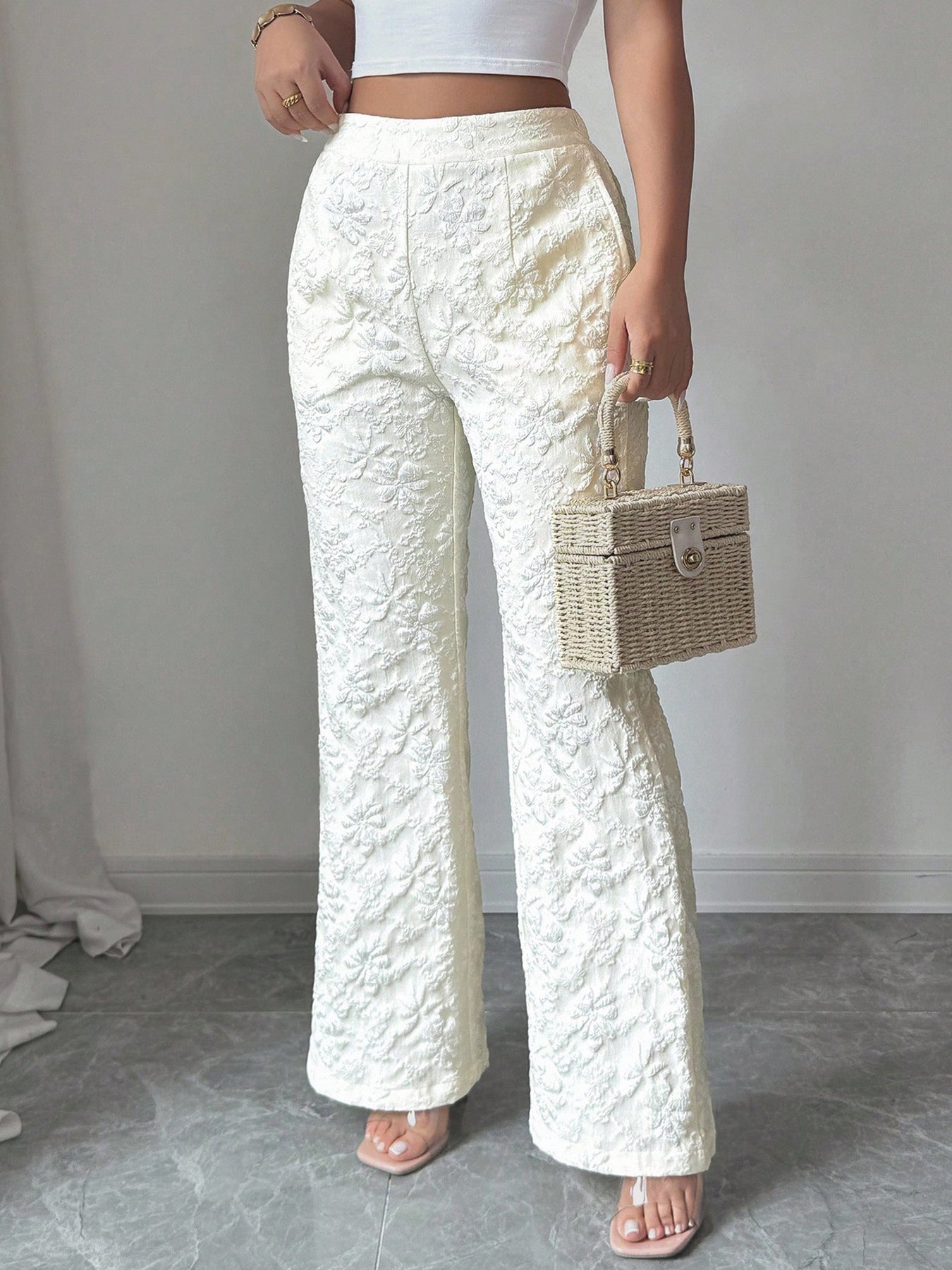 Textured white high-waist wide-leg maternity pants with pockets, shown with a straw box bag.