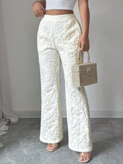 Textured white high-waist wide-leg maternity pants with pockets, shown with a straw box bag.