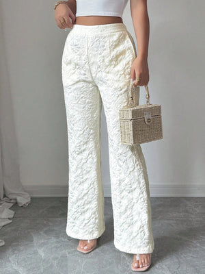 Textured white high-waist wide-leg maternity pants with pockets, shown with a straw box bag.