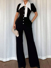 Button-down wide leg jumpsuit with a white collar and black body, featuring short sleeves and a button-up front.
