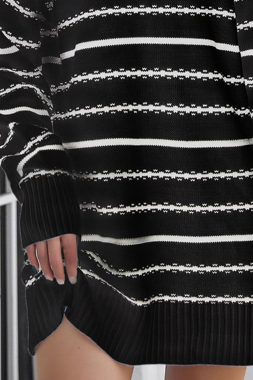 Black acrylic knit mini dress with white horizontal stripes and textured pattern.