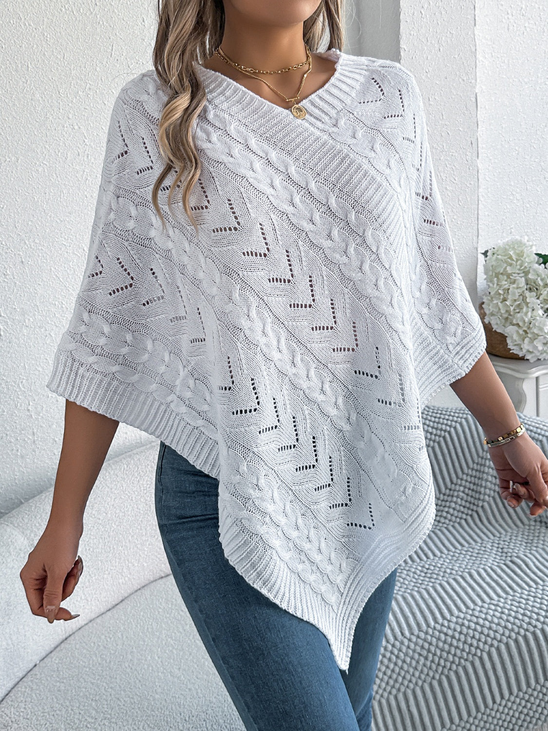 White acrylic cable knit poncho with chevron detail and V-neck