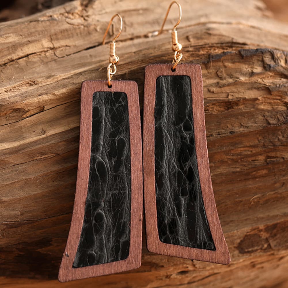 Tooled leather and wood drop earrings in black and brown with artisan detail.