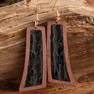 Tooled leather and wood drop earrings in black and brown with artisan detail.