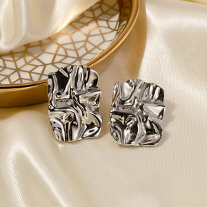 Textured silver sculptural stud earrings with an artistic, abstract design.