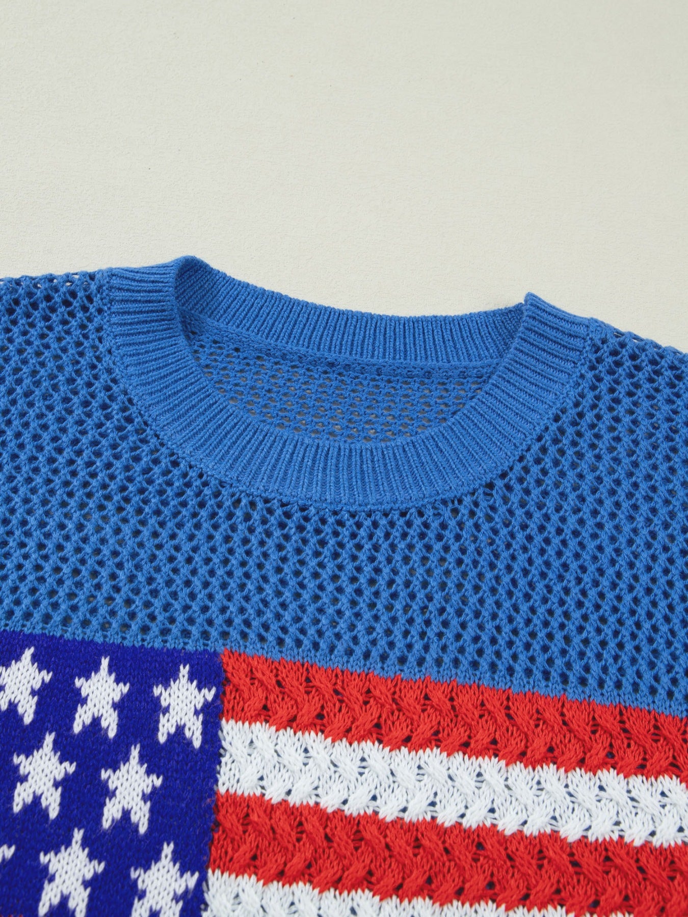 Patriotic flag graphic knit top with crew neck and open knit detail.