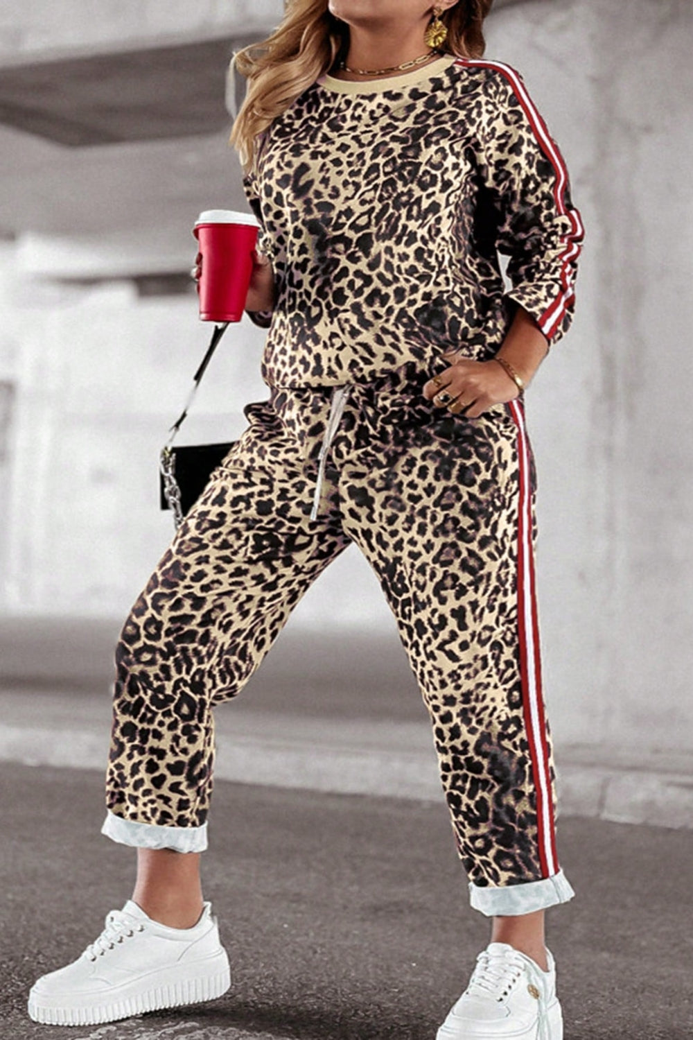 Leopard print joggers with sporty red and white side stripes, drawstring waist, and cuffed hem.