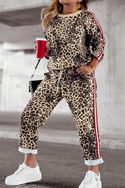 Leopard print joggers with sporty red and white side stripes, drawstring waist, and cuffed hem.