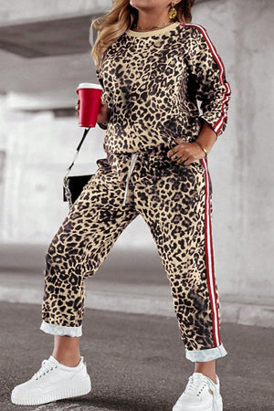 Leopard print joggers with sporty red and white side stripes, drawstring waist, and cuffed hem.