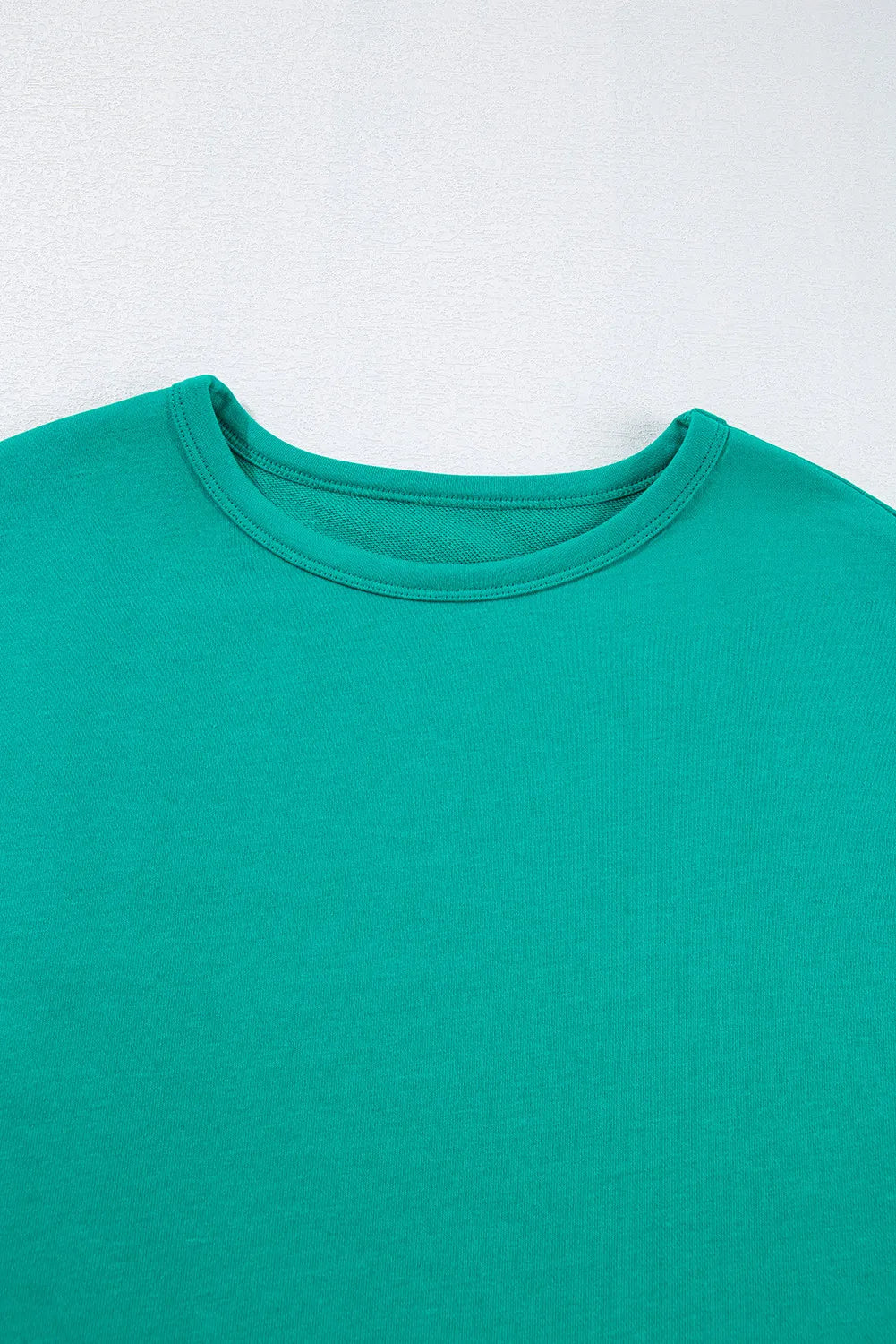 Turquoise crewneck sweatshirt with relaxed fit and crew neckline.
