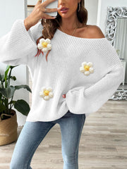 White slouchy knit sweater with floral appliqués and bell sleeves.