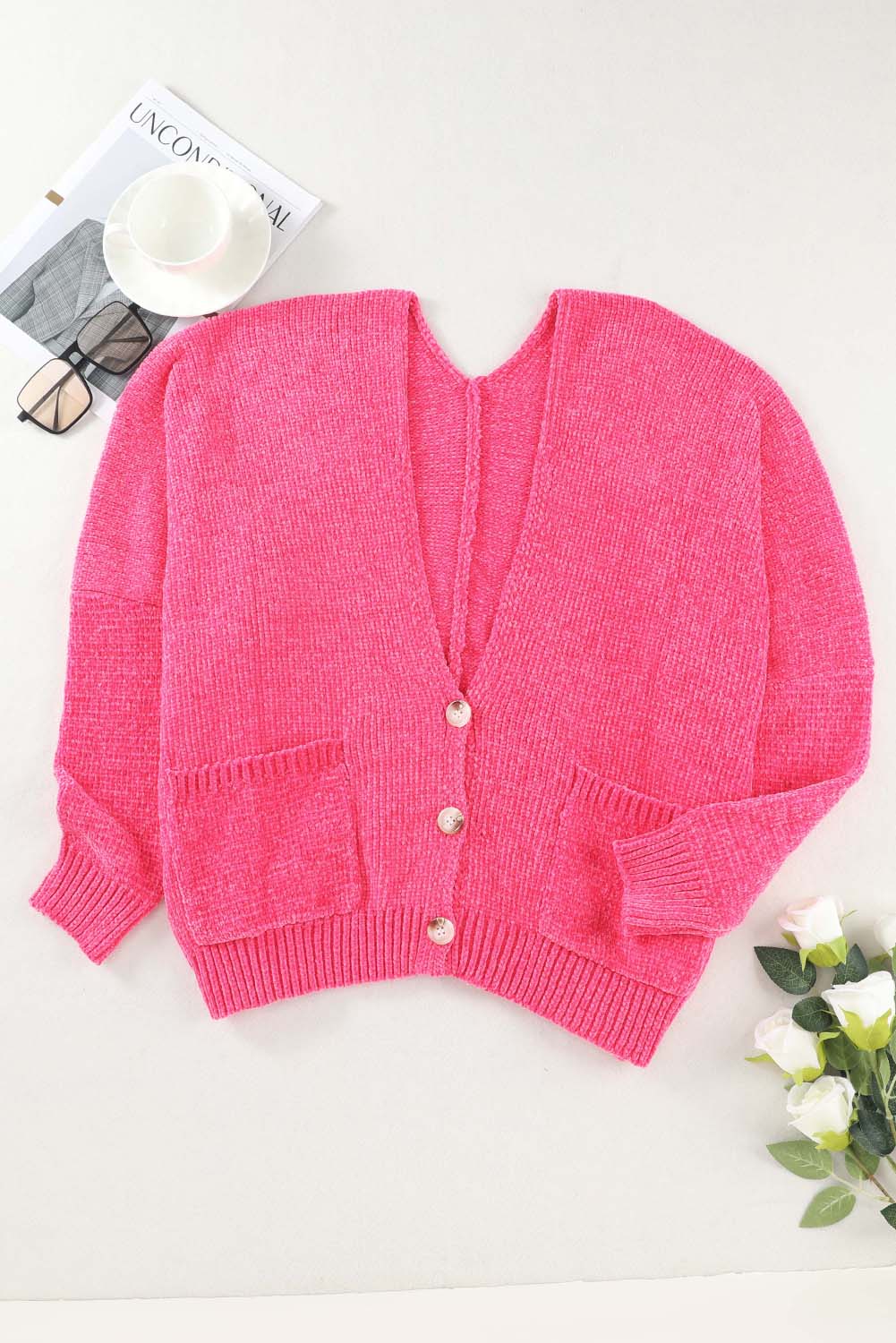 Plush pocket cardigan with deep V-neck in hot pink, featuring button front and ribbed cuffs.