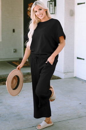 Black textured knit tee and wide leg pants set with drawstring waist and pockets.