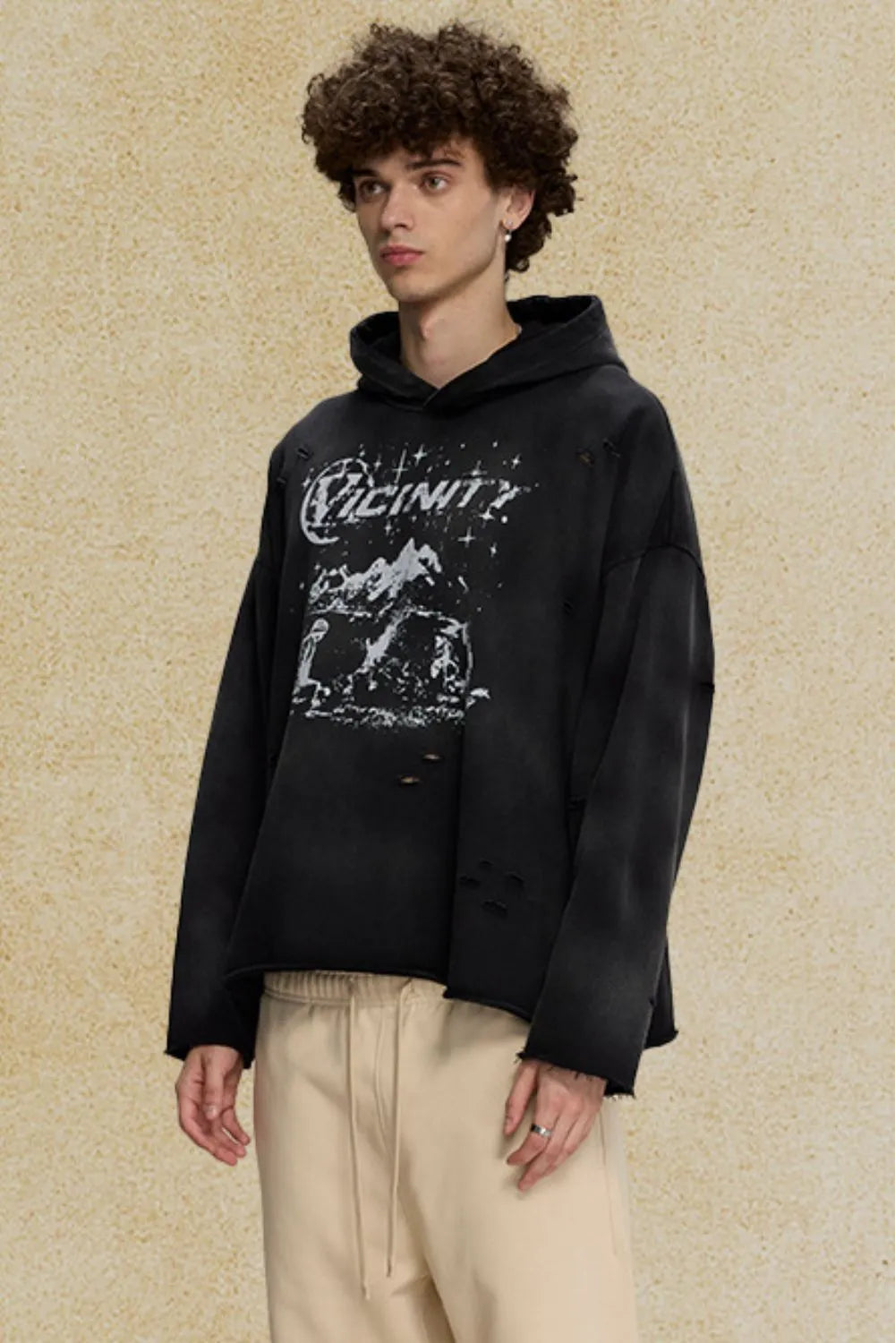 Black oversized distressed graphic hoodie with ripped details and a crew neck.