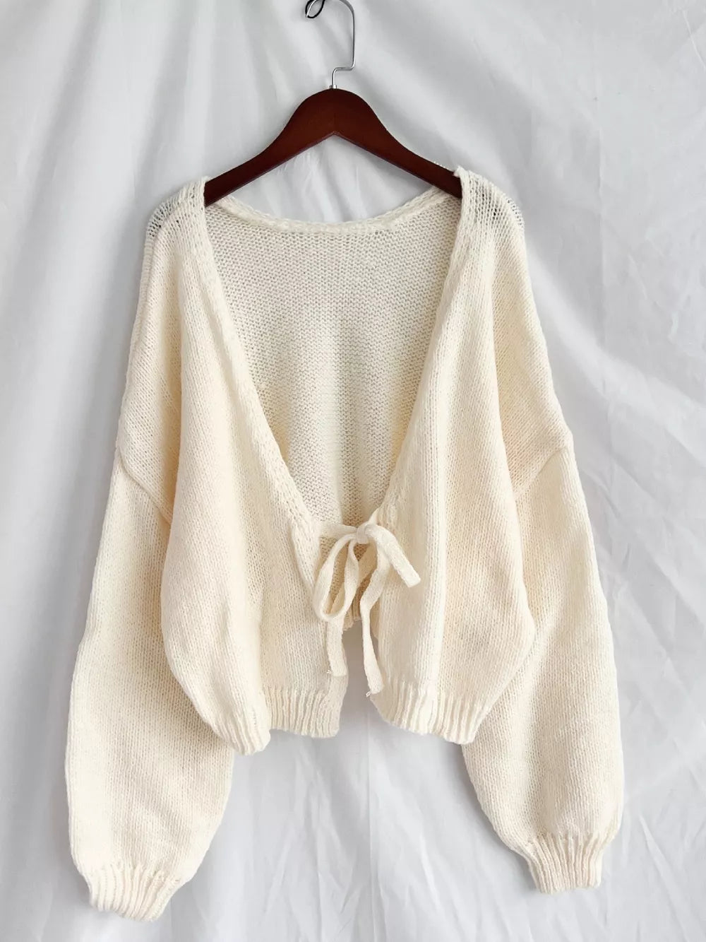 Cream textured tie-front knit cardigan with balloon sleeves and a relaxed fit.