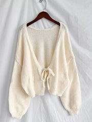 Cream textured tie-front knit cardigan with balloon sleeves and a relaxed fit.