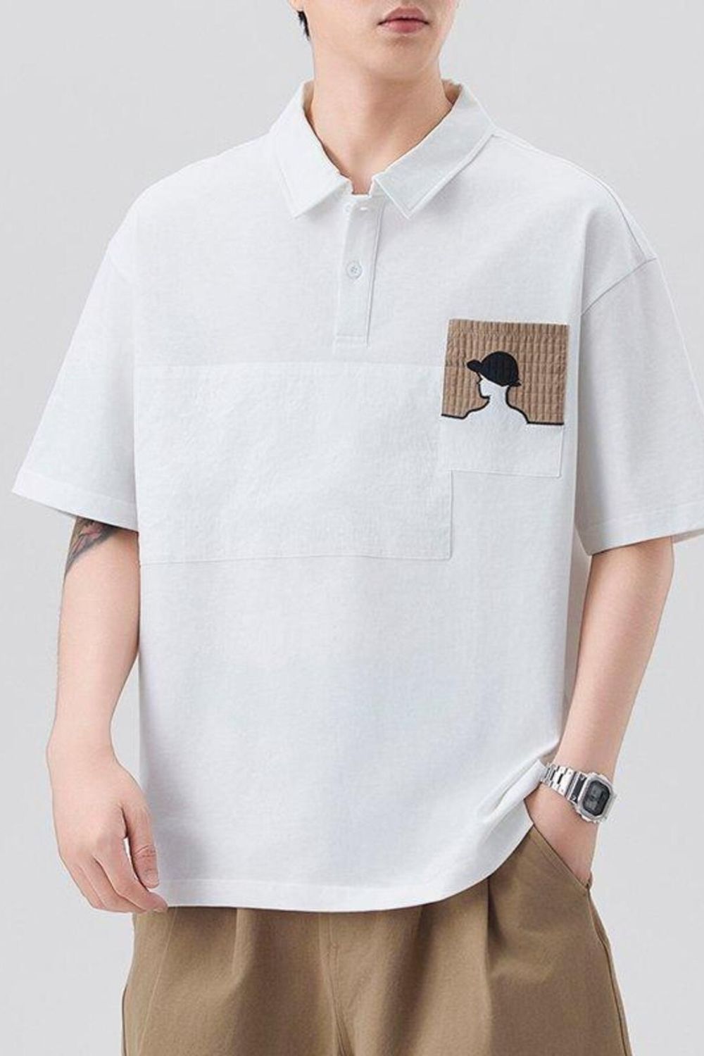 White polo shirt with embroidered pocket detail and buttoned collar.