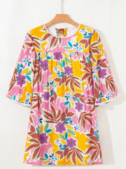 Print bell sleeve mini dress with colorful floral pattern and pom-pom trim.