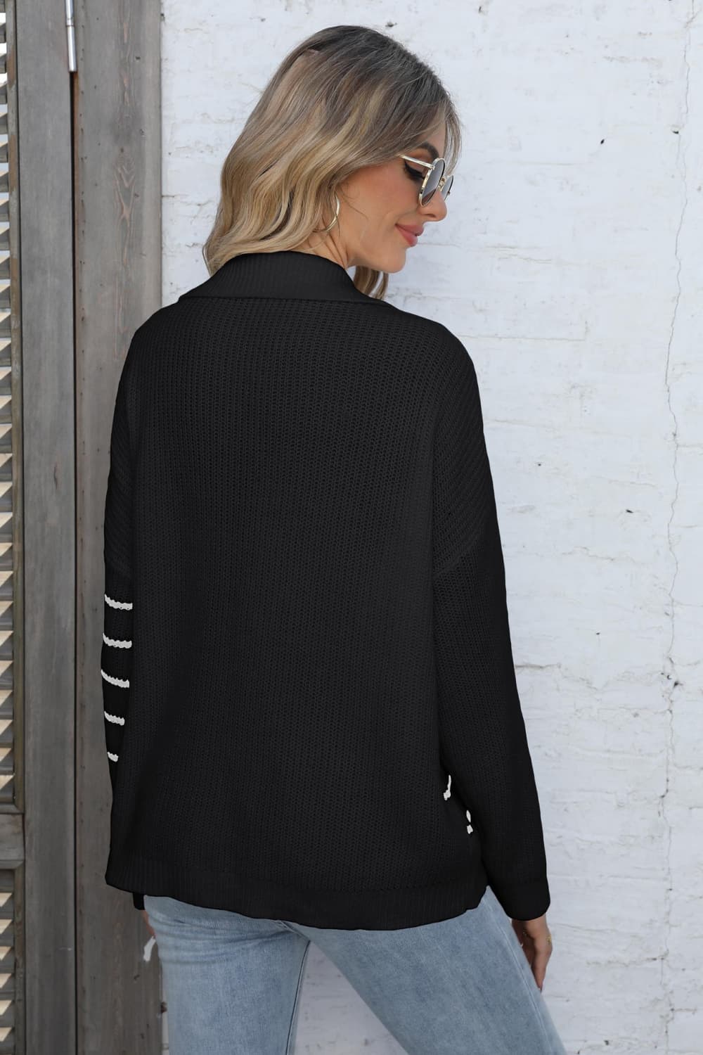Black collared knit sweater with white stripe detail on sleeves.