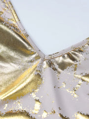 Maxi dress with V-neck and abstract gold pattern on cream fabric.