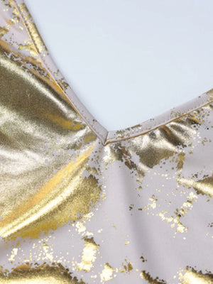 Maxi dress with V-neck and abstract gold pattern on cream fabric.