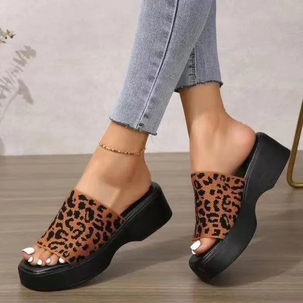 Platform knit slide sandals in leopard print with black soles and a thick sole.