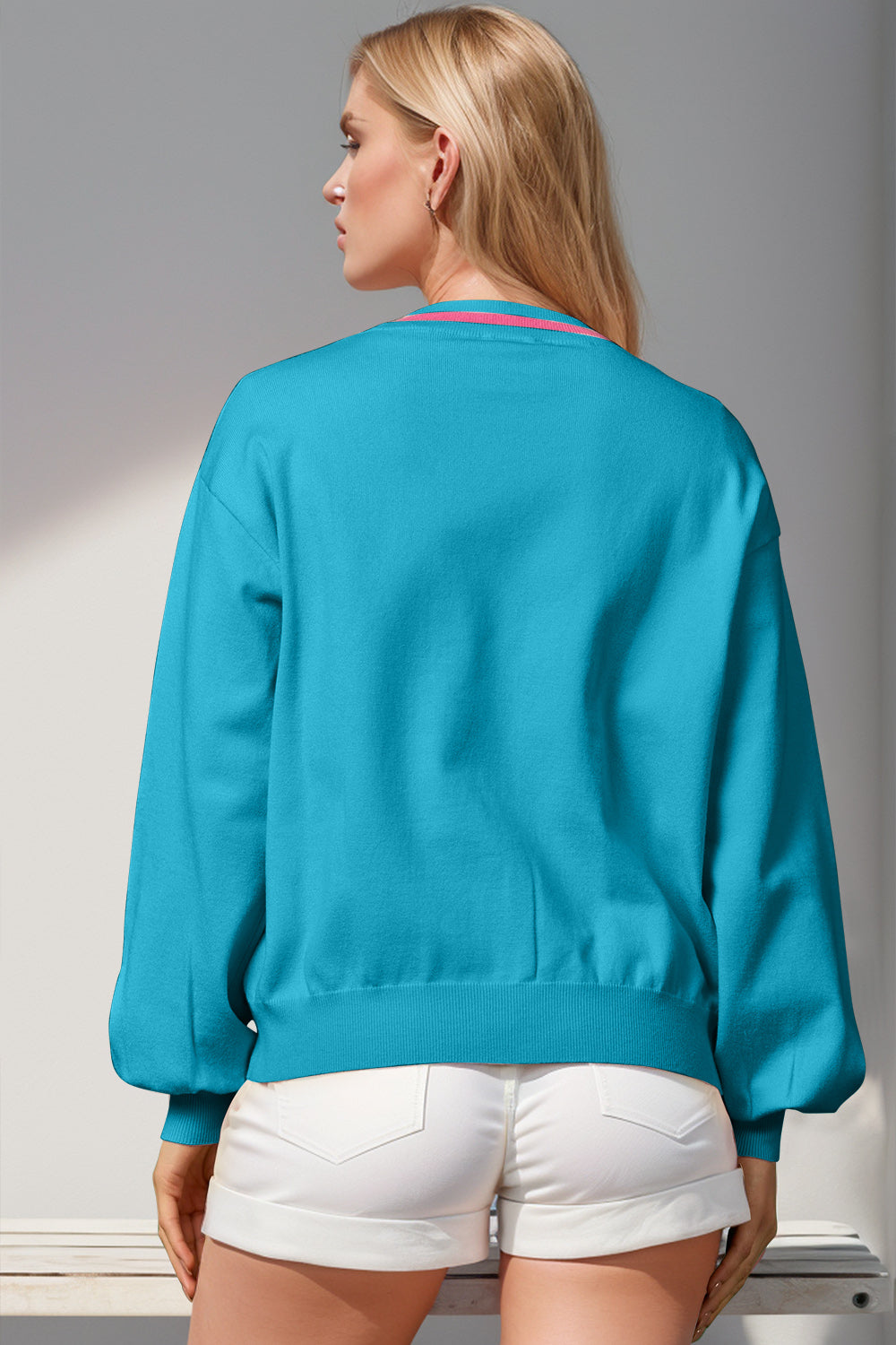 Cerulean acrylic cardigan with pink striped neckline detail and balloon sleeves.