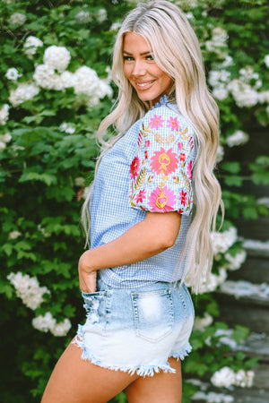 Light blue gingham blouse with embroidered floral puff sleeves.
