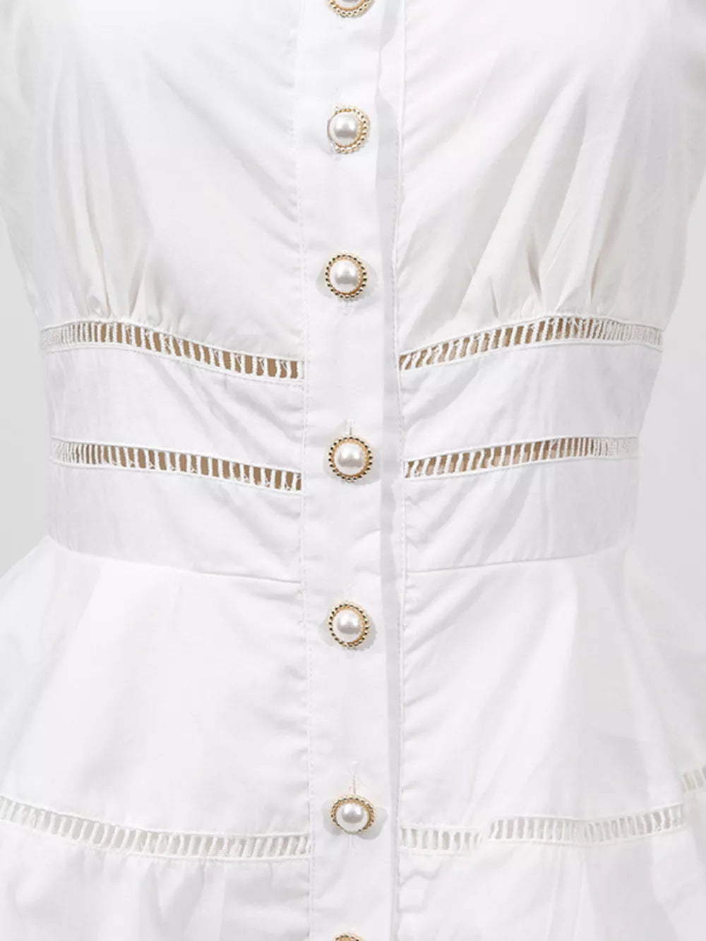 White eyelet midi dress with pearl button detail and cutout waist.