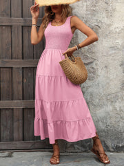 Pink smocked bodice tiered maxi dress with square neckline and sleeveless cut.