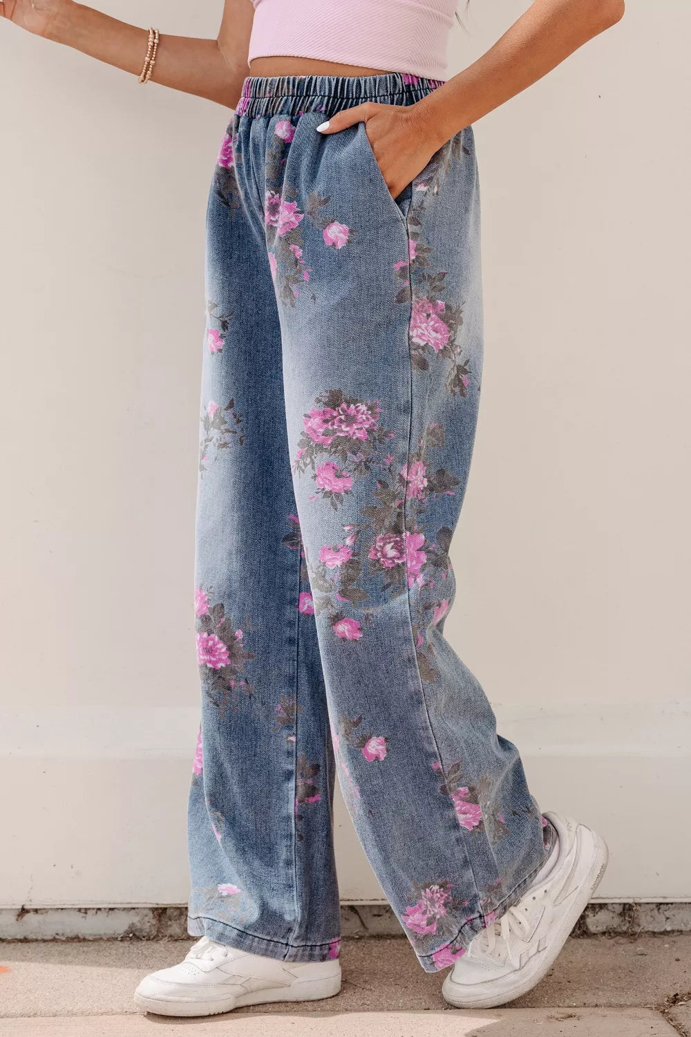 Floral wide-leg jeans with elastic waistband and pink floral print on denim.